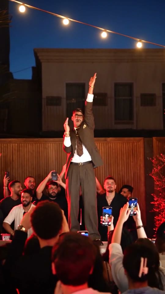 Cheba Man AI dance with a central performer wearing a suit and tie