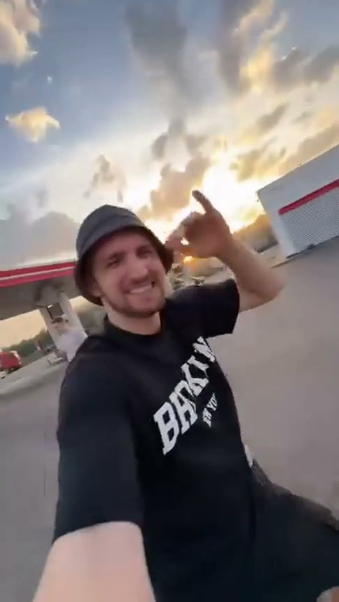 Source selfie of the camera operator in a dark shirt and bucket hat