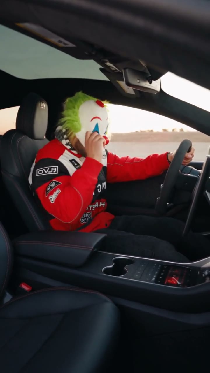 A driver in a red and white jacket inside a community version of the chase.